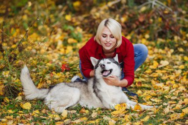 Güzel beyaz kız sonbahar orman veya park husky köpek ile çalış