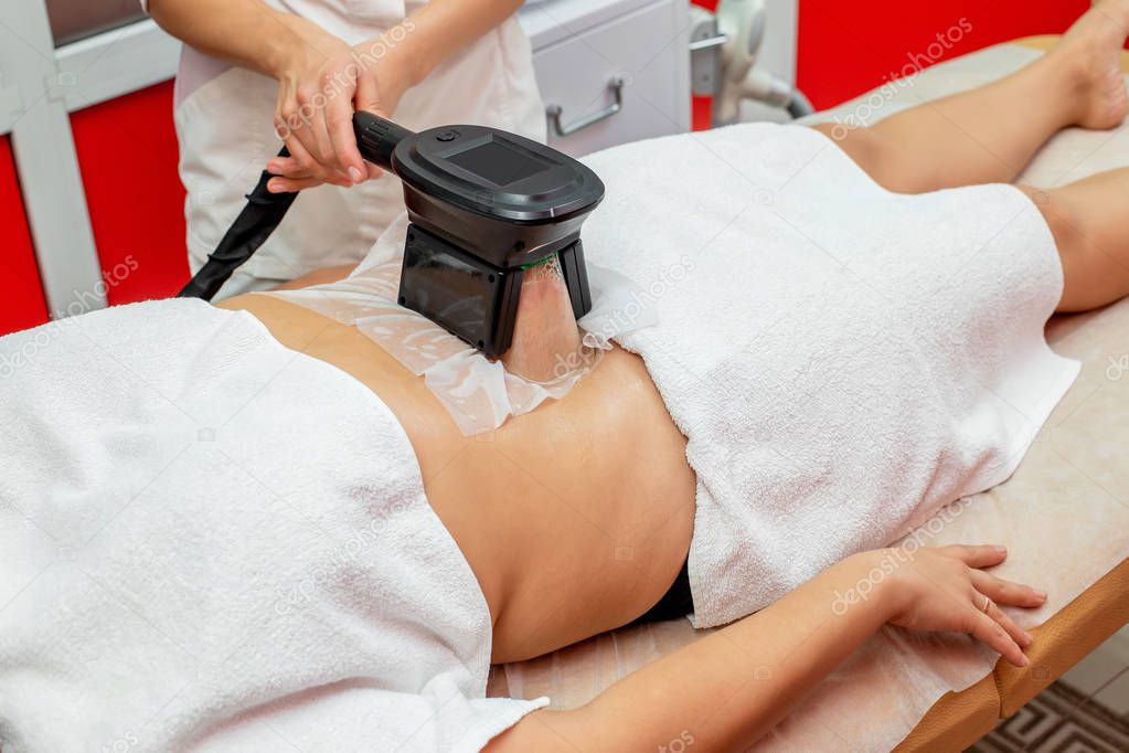 Woman getting cryolipolysis fat treatment procedure in professional cosmetic cabinet or spa center