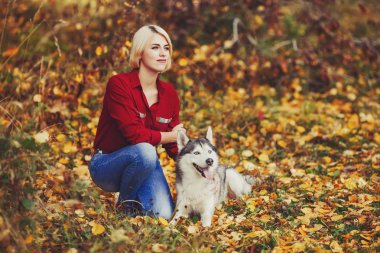 Güzel beyaz kız sonbahar orman veya park husky köpek ile çalış