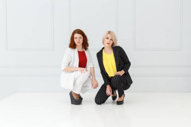 Moda portre ışık arka plan üzerinde beyaz ve siyah elbiseli kadınların