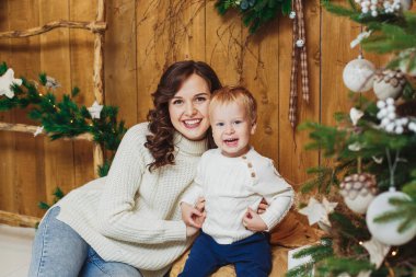 Mutlu anne ve oğul portresi. Kadın ve bebek çocuk. Noel ve yılbaşı süsleri