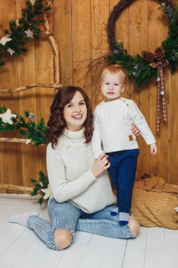 Mutlu anne ve oğul portresi. Kadın ve bebek çocuk. Noel ve yılbaşı süsleri