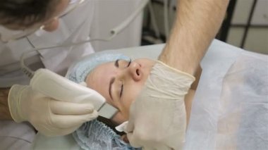 Yüz ile güzellik salonda ultrasonik yüzey temizleme prosedürü yapıyor güzellik uzmanı