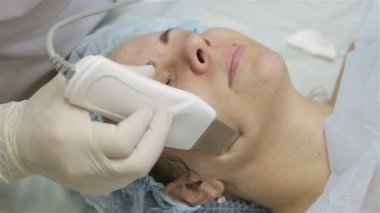 Yüz ile güzellik salonda ultrasonik yüzey temizleme prosedürü yapıyor güzellik uzmanı