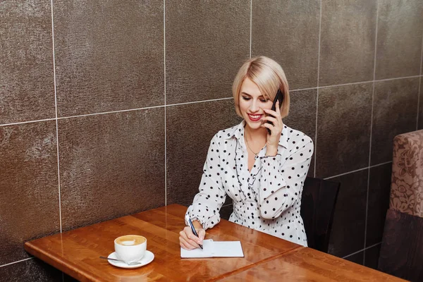 Γυναίκα Εργασία Καφενείο Μιλά Στο Τηλέφωνο Και Γράφοντας Στο Σημειωματάριο — Φωτογραφία Αρχείου