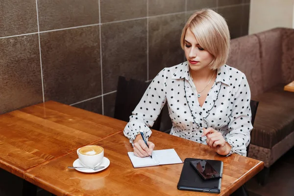 Γυναίκα Των Επιχειρήσεων Στη Καφετέρια Κάθεται Και Γράφοντας Στο Σημειωματάριο — Φωτογραφία Αρχείου