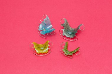 Renkli diş diş teli veya hizmetli pembe arka plan, closeup üzerinde dişler için