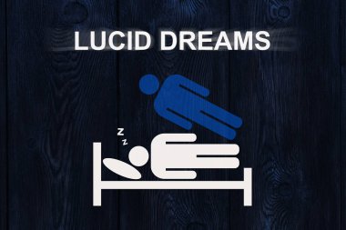 Paper sleeping man on bed with text LUCID DREAMS. Out of body, astral projection experience concept clipart