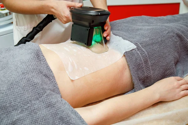 Güzellik terapisti cryolipolysis tedavisi uyguluyor. Cerrahi olmayan yağ azaltma
