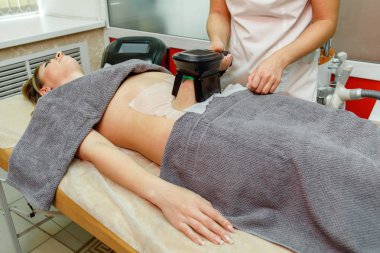 Güzellik terapisti cryolipolysis tedavisi uyguluyor. Cerrahi olmayan yağ azaltma