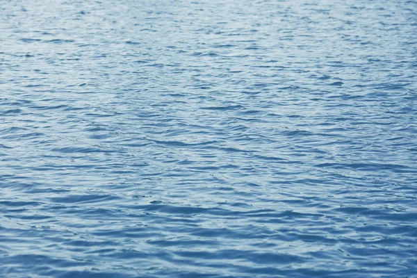 Brilhando azul ondulado superfície da água ondulação fundo — Fotografia de Stock