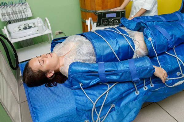 Mujer en traje de presoterapia acostada con terapia de presión — Foto de Stock