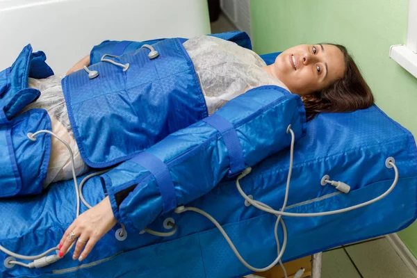 穿压疗服的妇女躺下接受压力治疗 — 图库照片