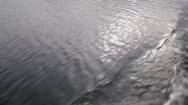 Hızlı hareket eden göl yüzeyi. Teknenin yanında dalgalı su. Doğa arka plan, yavaş çekim