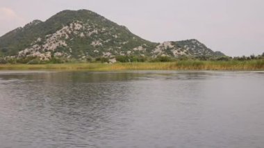 Karadağ'daki Skadar Gölü'nün doğa manzaraları gemiden alınmıştır. Yeşil dağlar panorama, yavaş hareket