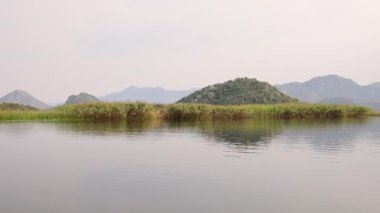 Karadağ'daki Skadar Gölü'nün doğa manzaraları gemiden alınmıştır. Yeşil dağlar panorama, yavaş hareket