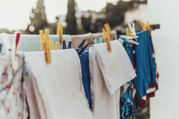 Rope with clean clothes attached with clothespin — Stock Photo, Image