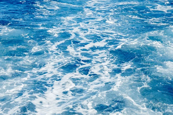Blå havsyta bakgrund med stänk vågor — Stockfoto