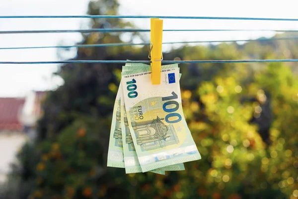 Notas de euro penduradas no varal. Conceito de negócio de branqueamento de capitais — Fotografia de Stock