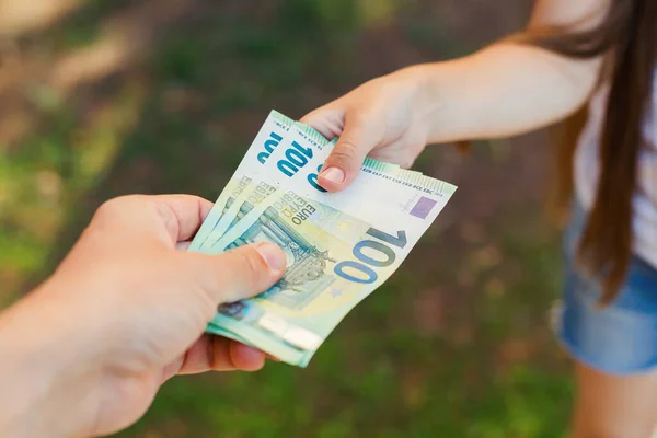 Mano masculina da dinero a un niño, billetes de cien euros — Foto de Stock