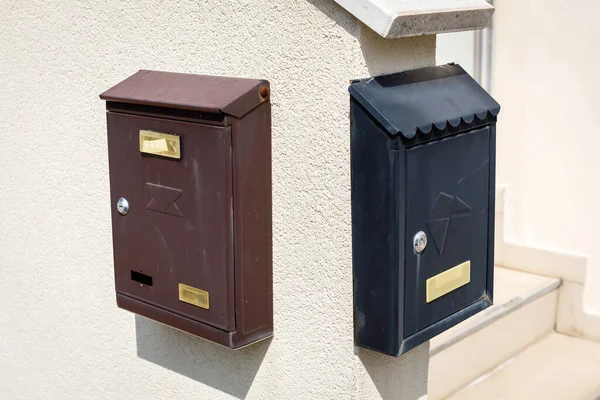 Old brown and black metallic retro post boxes on wall