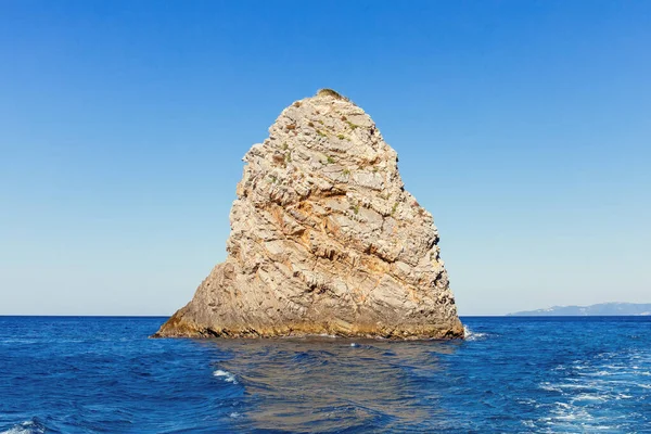 Roccia singola con acqua di mare blu chiaro — Foto Stock