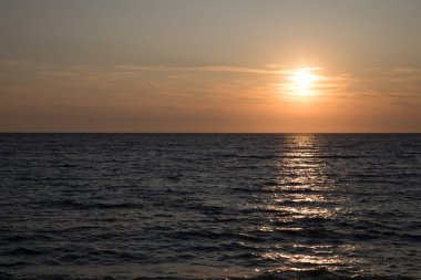 Dalgalar ve güneş yansıması ile karanlık deniz yüzeyi