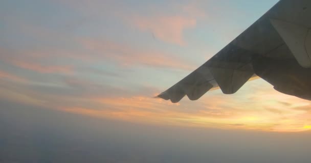View from airplane window on the wing on sunse over clouds — Stock Video