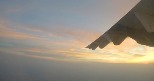 View from airplane window on the wing on sunse over clouds — Stock Video