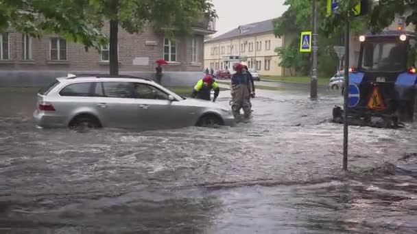 ミンスク。ベラルーシ - 21。05.2018: 市では、大雨の後の通りに殺到しました。救助避難ヨーロッパの都市で引込められた壊れた車. — ストック動画