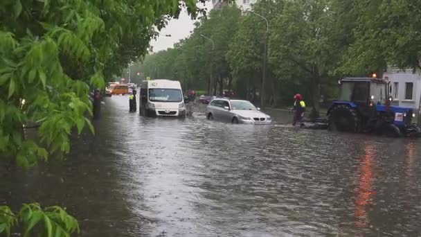 Minsk. Wit-Rusland - 21. 05.2018: overstroomde straten na zware regenval in de stad. Reddertjes evacueren verzonken gebroken auto's in de Europese stad. — Stockvideo