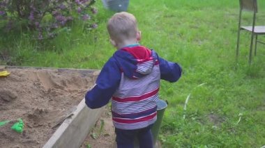 Küçük bir çocuk bir kum ile çalış ve spor ayakkabı gelen kum mendil.