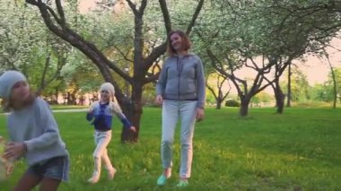Anne ve iki kızı bahar Park çiçek bahçesinde topuyla sporu. Etkin boş.
