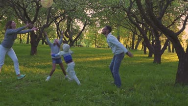 Anne ve iki kızı bahar Park çiçek bahçesinde topuyla sporu. Etkin boş.