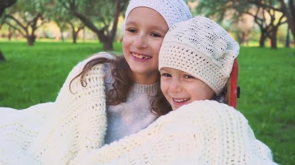 Two adorable little sisters hugging and cuddling outdoors on beautiful spring day. Family bond. Have fun laughing — Stock Video