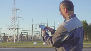 memnun elektrikçi başarı sevinir. Mühendisi ve elektrik alt istasyonlar görevli. İşçi tablet ve elektrik alt istasyonlar toplantıda içinde clipboard ile.
