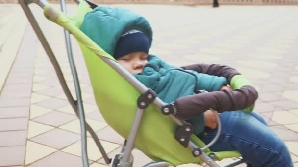 1 歳の男の子彼のベビーカーで寝ています。旅行中に眠りに落ちる — ストック動画