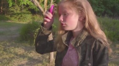 Onbir yıl yaşında sarışın kız saçları tarak Günbatımında