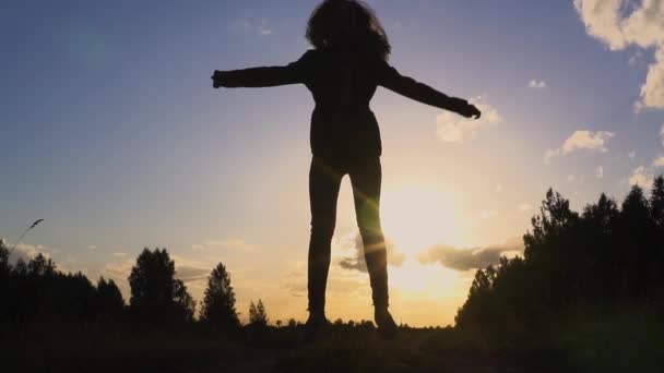 Sziluettjét fiatal nő naplemente lassú mozgás ugrás — Stock videók