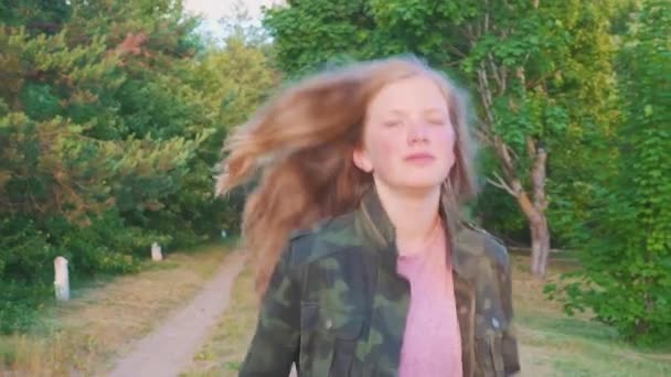 Adolescente con el pelo largo corriendo a lo largo de un camino en el bosque. Chica corre a lo largo del camino del bosque Slow Motion — Vídeo de stock