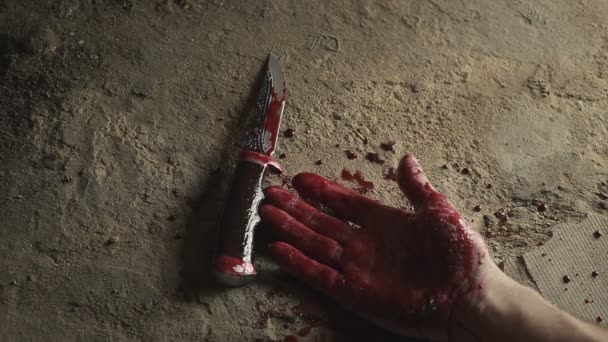 Una mano sangrienta con un cuchillo. El concepto de asesinato. Halloween — Vídeo de stock