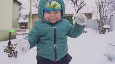 Bir yıl yaşlı erkek çocuk kar bahçede oynuyor.