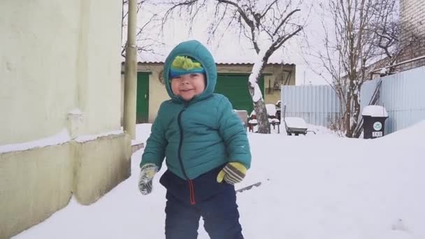 Um ano de idade menino joga no quintal de neve — Vídeo de Stock