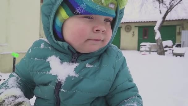 Niño de un año juega en el patio de nieve — Vídeos de Stock