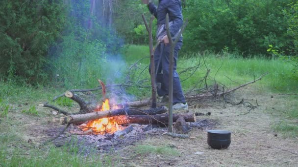 El viajero corta madera para hacer fuego y cocinar comida 4k — Vídeo de stock