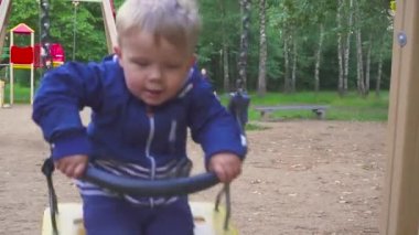 iki yıl eski çocuk parkta bir salıncak üzerinde sürme
