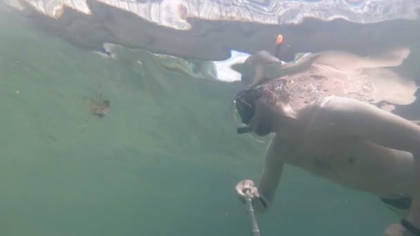 Muž ponory a dělá selfie pod vodou. — Stock video