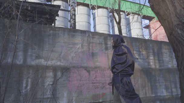 Grim reaper of de engel van de dood op industriële omwalling landschap gaat naar de camera en de lens met de hand sluit. — Stockvideo