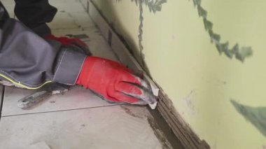 Çalışan küçük fayans mutfak duvar ayarlar. Elleri döşeme üzerinde yapışkan yerleştirir. çekim stedikam