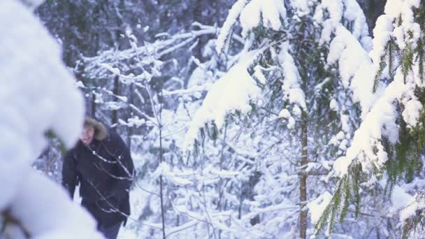 Ο άνθρωπος περπάτημα δάσος χειμώνα χιόνι ταξιδιώτη με σακίδιο. κουνώντας το χέρι του στην κάμερα — Αρχείο Βίντεο